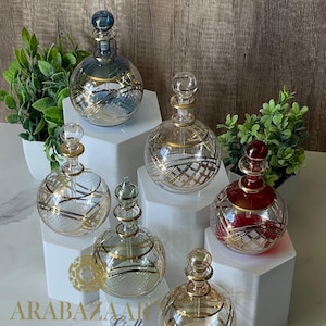 Botella de perfume de vidrio soplado a mano con diseño de globo egipcio grabado y detalles en oro de 14 quilates.