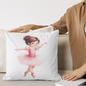 Op de afbeelding: Wit vierkant kussen met een aquarel illustratie van een jonge ballerina in een roze tutu en balletschoenen. De ballerina heeft bruin haar en staat in een sierlijke pose, armen uitgestrekt. Het kussen ligt op een licht oppervlak.