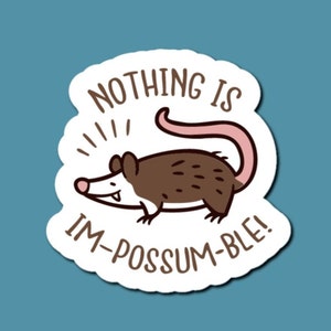 May include: White sticker with a cartoon possum and the text "Nothing is im-possum-ble!"