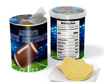 May include: A cylindrical container with a football theme, featuring the text "Aiden's 11th Birthday" and a football graphic. The container has a lid with the text "Thanks for making my touchdown". A small plate holds a stack of chips.
