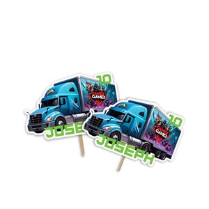 May include: Two blue semi-truck cupcake toppers. Each truck has a "Gamer Gamer" graphic on the trailer and the number "10". The name "JOSEPH" is printed on each topper. The toppers are attached to wooden sticks.