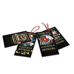 May include: Four black casino-themed gift tags with red string. Each tag features casino imagery like roulette wheels, playing cards, and poker chips. The tags include the text "THANK YOU" and "MICHAEL". Gold coins are scattered on the tags.