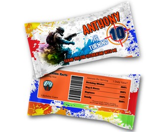 May include: A colourful party favour bag with a paintball theme. The bag features a soldier holding a paintball gun and the text "Anthony is turning 10. Thank you for celebrating with me." The back of the bag has a nutrition facts label with a paintball mask graphic and the text "Amount Per Serving: Birthday Wishes 250%, Hug & Kisses 250%, Happiness 250%, Family 250%. *Percent Daily Values are based on average happy and loveable kids."