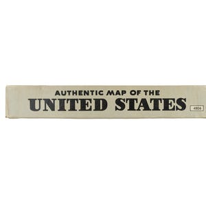 K&ouml;nnte beinhalten: Eine rechteckige, cremefarbene Seitenwand einer Schachtel mit dem schwarzen Text AUTHENTIC MAP OF THE UNITED STATES in einer fetten serifenlosen Schrift. Die Nummer 4806 ist in einem kleinen schwarz umrandeten Feld rechts aufgedruckt.