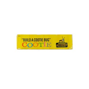 K&ouml;nnte beinhalten: Ein rechteckiger gelber Spielkarton f&uuml;r Build a Cootie Bug von Schaper. Der Text lautet Build a Cootie Bug in Schwarz, wobei das Wort Cootie in bunten Buchstaben geschrieben ist. Eine kleine schwarz-wei&szlig;e Grafik eines K&auml;fers ist neben dem Schaper-Logo.