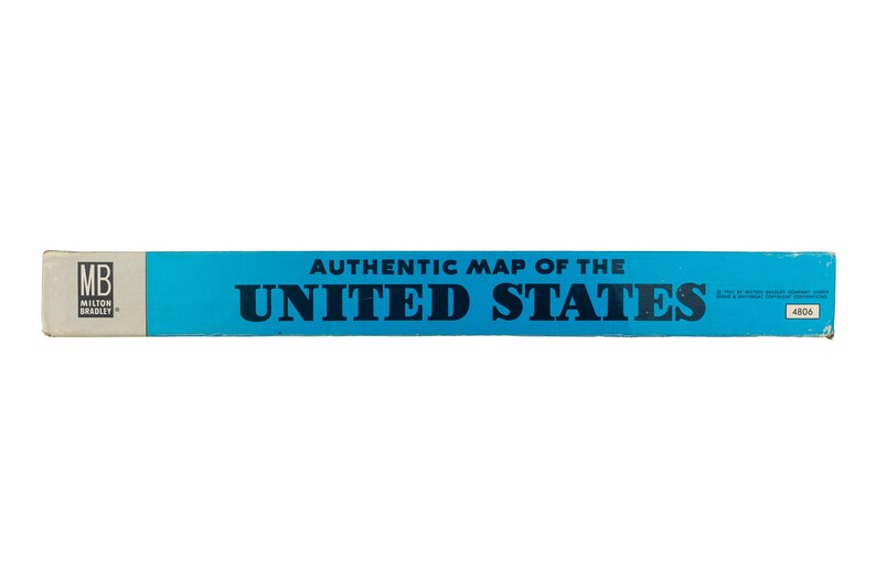 K&ouml;nnte beinhalten: Eine rechteckige Spielschachtel-Seitenwand mit hellblauem Hintergrund und schwarzem Text, der AUTHENTIC MAP OF THE UNITED STATES lautet. Links befindet sich ein wei&szlig;es Quadrat mit dem schwarzen MB Milton Bradley Logo und rechts die Nummer 4806.