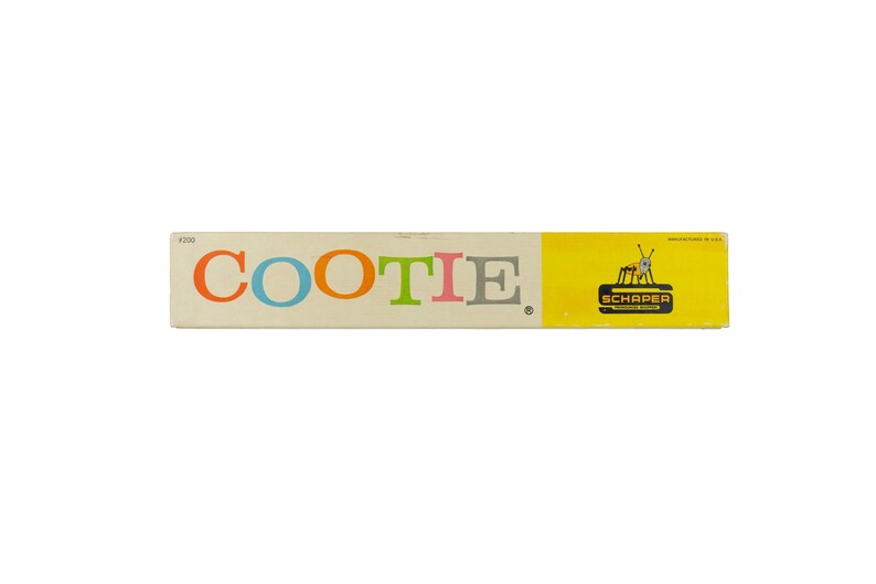 K&ouml;nnte beinhalten: Eine rechteckige Spielschachtel f&uuml;r Cootie mit dem Wort COOTIE in bunten Buchstaben auf cremefarbenem Hintergrund. Die rechte Seite ist leuchtend gelb mit einem schwarzen Schaper-Logo und einer kleinen Grafik eines k&auml;ferartigen Wesens mit Antennen.