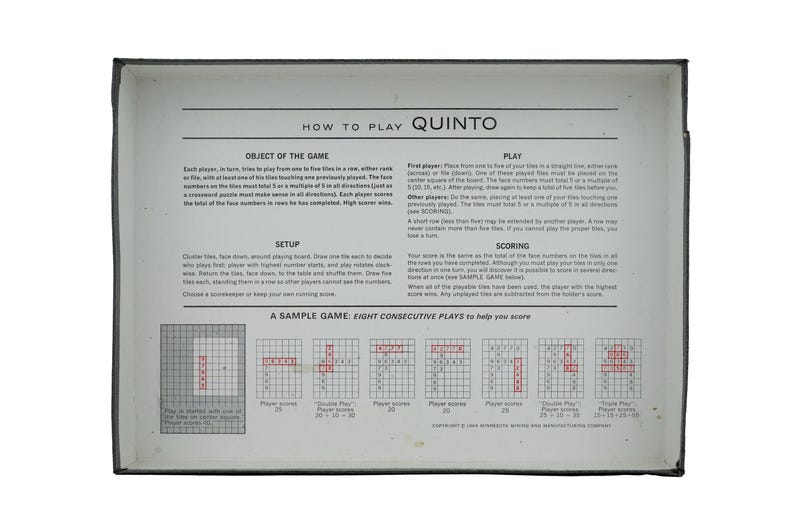 May include: The interior of a Quinto board game box lid featuring printed instructions titled HOW TO PLAY QUINTO. The text outlines the object of the game, setup, play, and scoring, accompanied by a grid diagram labelled A SAMPLE GAME.