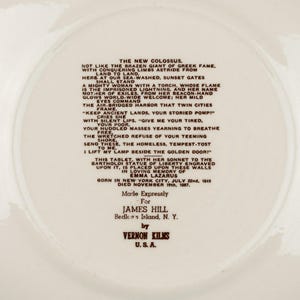 K&ouml;nnte beinhalten: Ein cremefarbener Keramikteller mit dem vollst&auml;ndigen Text des Gedichts The New Colossus von Emma Lazarus in dunkelbrauner Schrift. Die Mitte enth&auml;lt Angaben zur Bartholdi-Freiheitsstatue und zum Hersteller, Vernon Kilns, U.S.A.