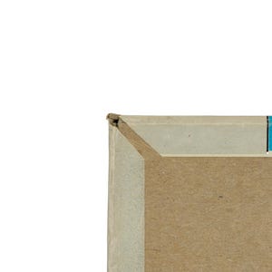 K&ouml;nnte beinhalten: Eine Nahaufnahme der oberen linken Ecke eines rechteckigen Pappkartons. Der Karton hat einen hellgrauen Rand entlang der Oberkante, einen leuchtend blauen vertikalen Streifen auf der rechten Seite und eine schlichte braune Pappoberfl&auml;che.