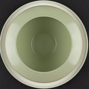 Peut inclure: Une vue de dessus d'un bol rond en c&eacute;ramique pr&eacute;sentant un int&eacute;rieur lisse vert sauge clair et un large bord plat. Le bord ext&eacute;rieur est fini avec une bande blanche unie et nette qui encercle toute la circonf&eacute;rence du bol.