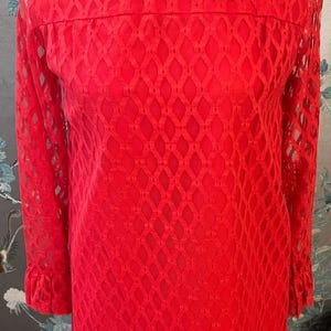 May include: A red, long-sleeved dress with a diamond-shaped lace pattern. The dress has a high neckline and a fitted silhouette.