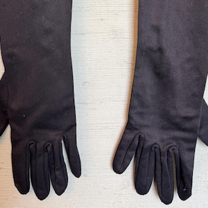 Peut inclure: Une paire de longs gants noirs avec des bouts de doigts. Les gants sont faits d'un tissu doux et extensible.