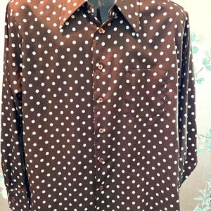 May include: A brown long-sleeved button-down shirt with a white polka dot pattern.