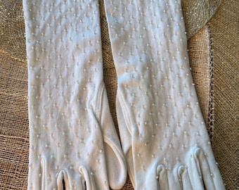 May include: A pair of white long gloves with a beaded pattern. The gloves are made of a soft, stretchy fabric and have a delicate, feminine look.