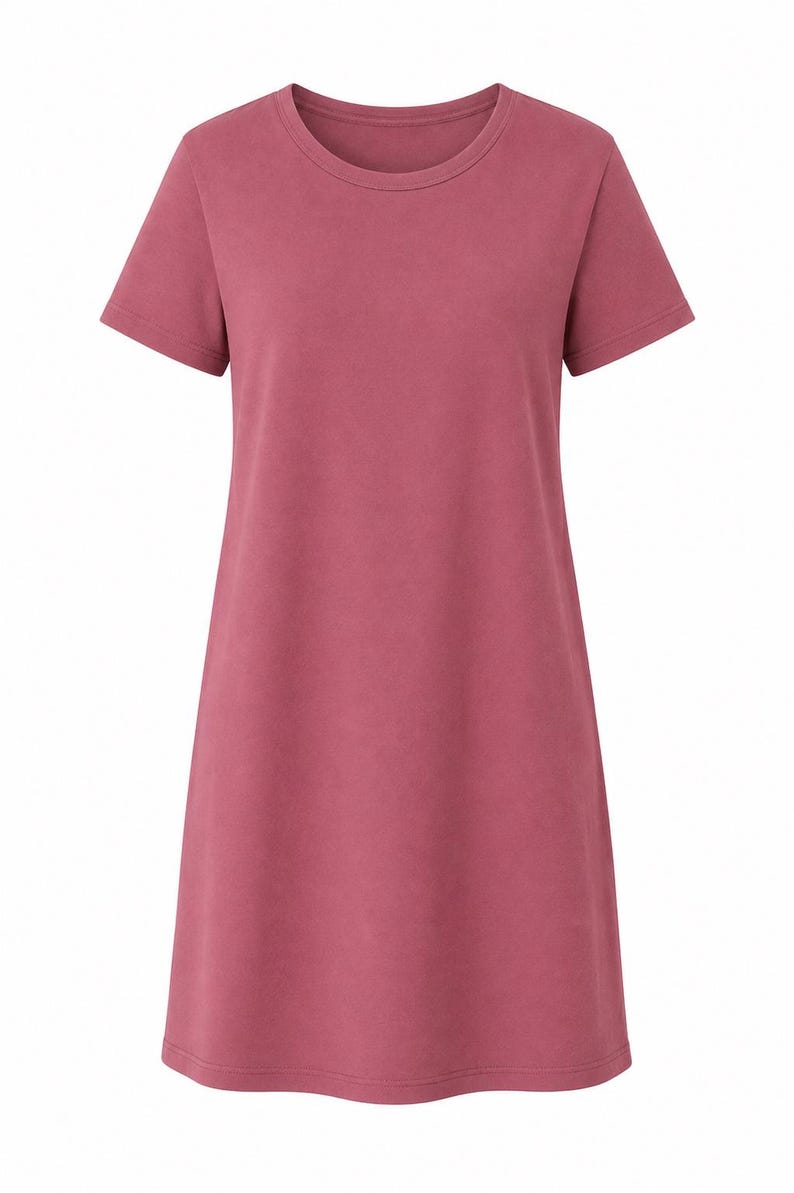May include: A solid dusty rose colored t-shirt dress featuring a round neckline, short sleeves, and a straight hemline. The garment has a simple, unadorned design with a consistent matte texture throughout the fabric, providing a clean and uniform look.