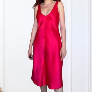 K&ouml;nnte beinhalten: Ein leuchtend pinkes, &auml;rmelloses Kleid mit V-Ausschnitt und flie&szlig;ender A-Linien-Silhouette.