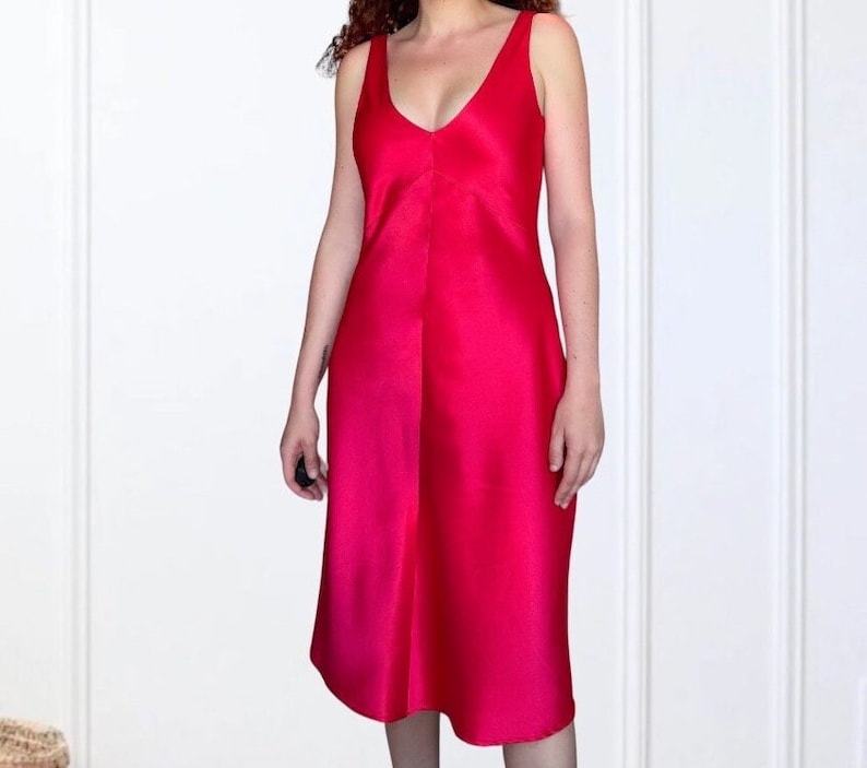 K&ouml;nnte beinhalten: Ein leuchtend pinkes, &auml;rmelloses Kleid mit V-Ausschnitt und flie&szlig;ender A-Linien-Silhouette.
