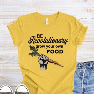 May include: Yellow t-shirt with the text "BE Revolutionary grow your own FOOD" and a cartoon hand holding a carrot.