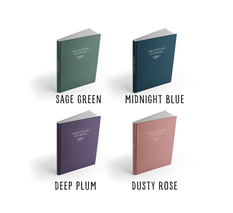 May include: Four hardcover journals with the text "Gratitude Journal" and a dragonfly design on the front cover. The journals are in four different colors: sage green, midnight blue, deep plum, and dusty rose.