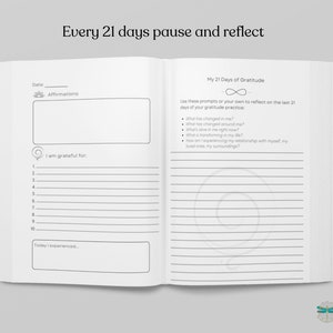 May include: A black and white journal with the text "Every 21 days pause and reflect" at the top. The left page has a section for affirmations, a list of things to be grateful for, and a space to write about what you experienced that day. The right page has a section for a 21-day gratitude practice with prompts to reflect on the last 21 days.