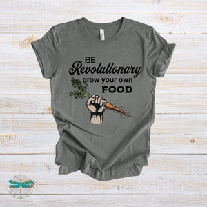 May include: A dark gray t-shirt with the text "BE Revolutionary grow your own FOOD" and a cartoon image of a fist holding a carrot.