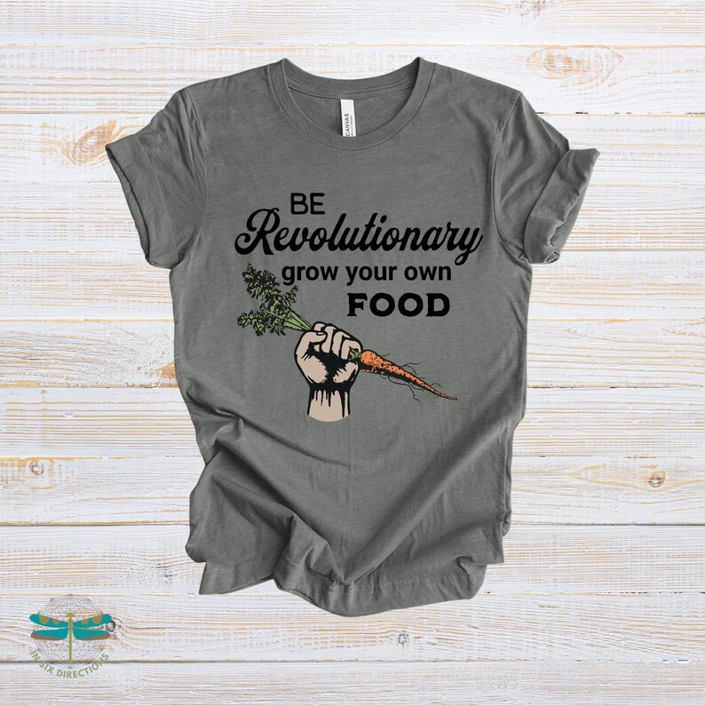 May include: A dark gray t-shirt with the text "BE Revolutionary grow your own FOOD" and a cartoon image of a fist holding a carrot.