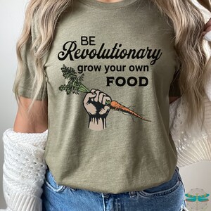 May include: A green t-shirt with the text "BE Revolutionary grow your own FOOD" and a cartoon fist holding a carrot.
