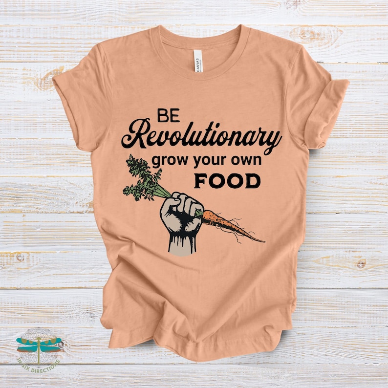 May include: A peach colored t-shirt with the text "BE Revolutionary grow your own FOOD" and a cartoon image of a fist holding a carrot.