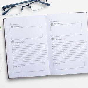 May include: A black and white gratitude journal with lined pages for writing down affirmations, things you are grateful for, and daily experiences. The journal has a simple design with a sun icon and the word "Affirmations" at the top of each page.