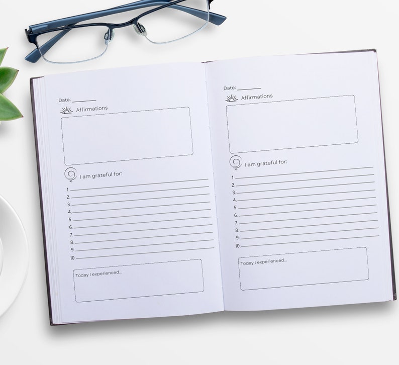 May include: A black and white gratitude journal with lined pages for writing down affirmations, things you are grateful for, and daily experiences. The journal has a simple design with a sun icon and the word "Affirmations" at the top of each page.