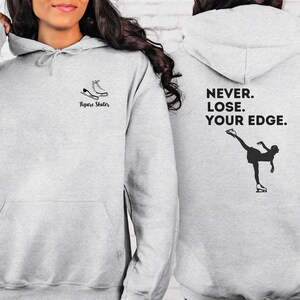 May include: Gray hooded sweatshirt with a figure skater graphic on the front and the text "NEVER. LOSE. YOUR EDGE." on the back.