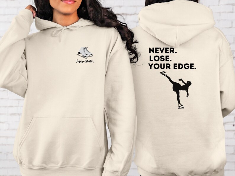 May include: A cream-colored hoodie with a figure skater silhouette and the text "Never. Lose. Your Edge." on the back. The front of the hoodie has a pair of ice skates and the text "Figure Skater".