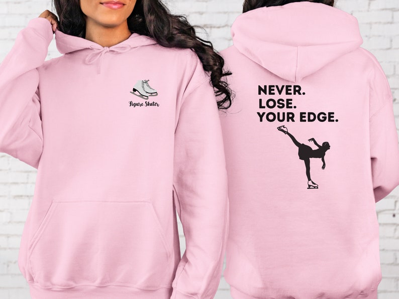 May include: Pink hoodie with a figure skater graphic on the front and the text "NEVER. LOSE. YOUR EDGE." on the back.