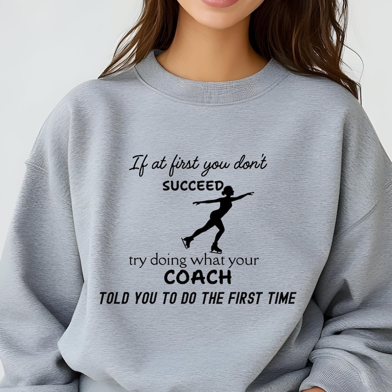 May include: A light gray sweatshirt with the text "If at first you don't succeed, try doing what your coach told you to do the first time." A black silhouette of a figure skater is also on the sweatshirt.