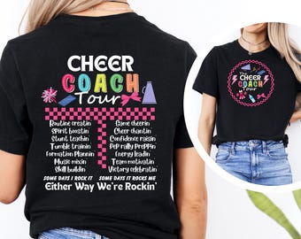 May include: Black t-shirt with the words "CHEER COACH Tour" in colorful text. The back of the shirt lists cheerleading-related phrases. A second image shows a similar design in a circular format. The shirt is a cheerleading coach's apparel.