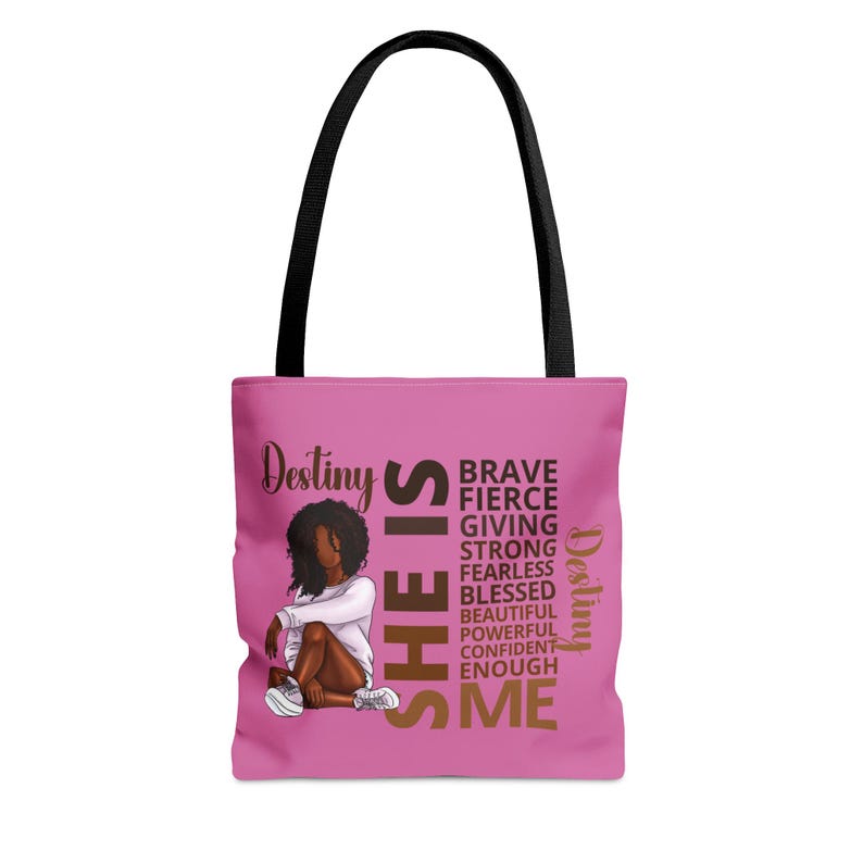 Pu&ograve; includere: Borsa tote rosa con manico nero e un'immagine di una donna con i capelli castani e una camicia bianca. Il testo sulla borsa recita "Destiny SHE IS BRAVE FIERCE GIVING STRONG FEARLESS BLESSED BEAUTIFUL POWERFUL CONFIDENT ENOUGH ME Destiny".