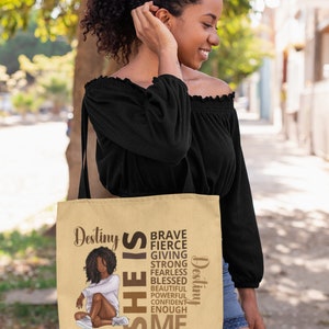 Pu&ograve; includere: Una borsa tote beige con un'illustrazione marrone di una donna e il testo "Destiny SHE IS BRAVE FIERCE GIVING STRONG FEARLESS BLESSED BEAUTIFUL POWERFUL CONFIDENT ENOUGH ME Destiny".