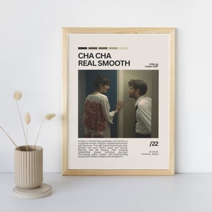 May include: A minimalist movie poster for the film "Cha Cha Real Smooth" featuring a couple looking at each other in a doorway. The poster is in a light wood frame and has a colour palette of beige, brown, and white.