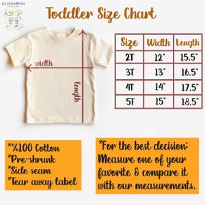 May include: Cream-colored toddler t-shirt with a size chart. The chart shows sizes 2T to 5T, with width measurements from 12" to 15" and lengths from 15.5" to 18.5". The shirt is 100% cotton, pre-shrunk, and has a side seam and tear-away label.