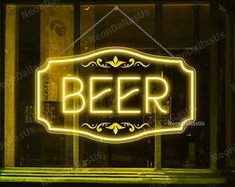 May include: A yellow neon sign with the word "BEER" in a decorative frame, hanging in a storefront window.