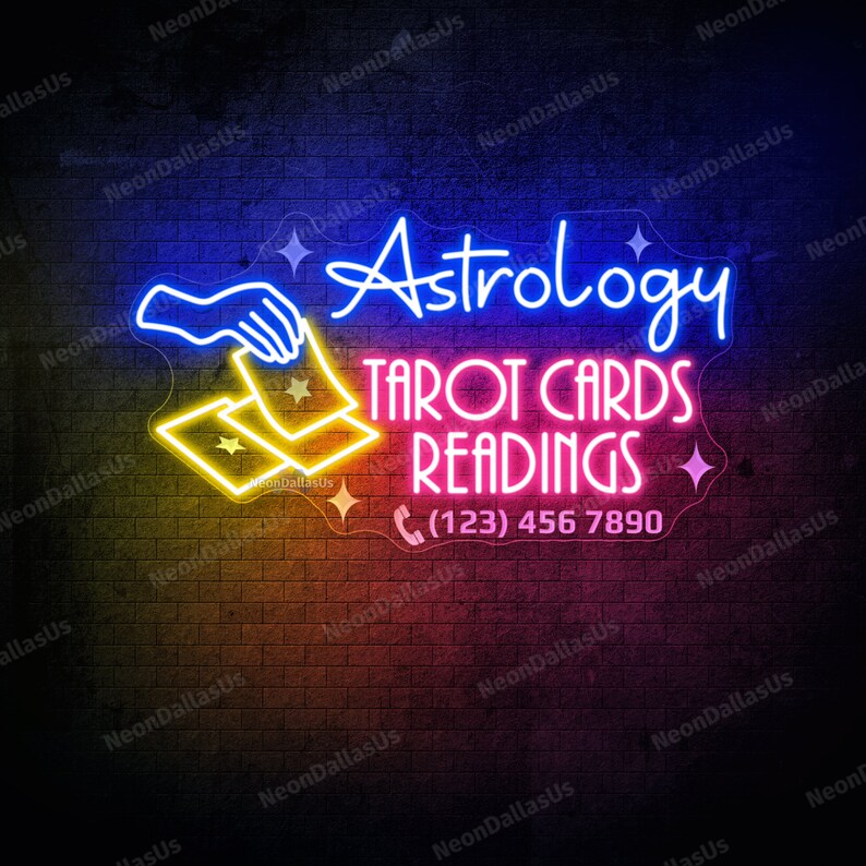 May include: Neon sign with a blue hand holding two yellow tarot cards. The sign reads "Astrology Tarot Cards Readings (123) 456 7890".
