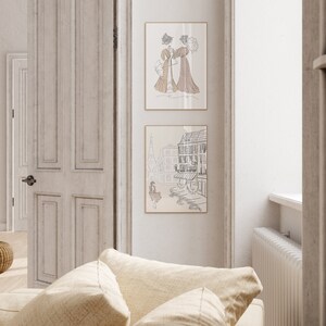 May include: Two framed art prints featuring line drawings. The top print depicts two women in vintage dresses with parasols. The bottom print shows a Parisian street scene with the Eiffel Tower. Both prints have a neutral color palette.