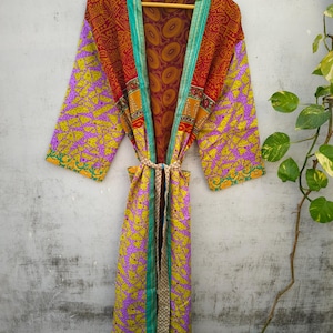 May include: A long, colorful silk robe with a floral pattern. The robe has a tie belt and is made of a patchwork of different fabrics.