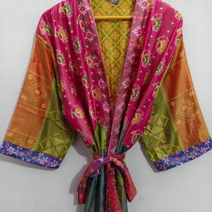 May include: A colourful silk robe with a patchwork design. The robe has a pink, green, orange and blue pattern. The robe has a tie belt and long sleeves.