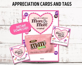 May include: Pink Valentine's Day appreciation cards and tags featuring a heart with the text "You make a difference More & More everyday!" and a bag of M&M's candy. The cards are decorated with small pink "m" letters.