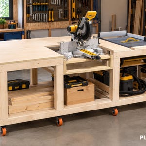 May include: A large, light-colored wooden workbench on orange casters featuring a built-in miter saw and a table saw. The structure includes open shelving underneath for tool storage, with various black and yellow power tools and clamps visible. The text PLANMAGE is in the bottom right corner.