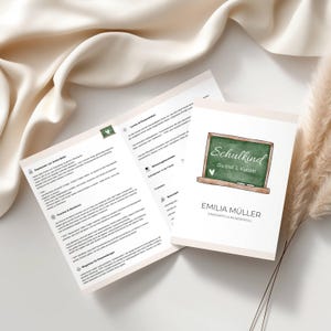 Peut inclure: Une carte blanche avec le texte "Schulkind" et "Du bist 1. Klasse!" sur un tableau noir. La carte comprend également le nom "EMILIA MÜLLER" et les mots "EINZIGARTIG & WUNDERVOLL". À côté, un livret ouvert avec du texte.