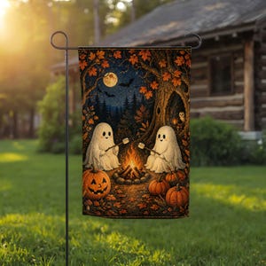 May include: A rectangular garden flag featuring two white ghosts roasting marshmallows over a campfire in a forest at night. The scene includes orange pumpkins, autumn leaves, a full moon, bats, and an owl in a tree hollow, all suspended on a metal stand.