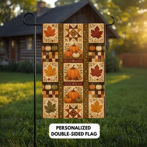Könnte beinhalten: Eine rechteckige Gartenflagge mit einem Patchwork-Design aus Herbstblättern und Kürbissen in Orange-, Braun- und Grüntönen. Die Flagge zeigt den Text PERSONALIZED DOUBLE-SIDED FLAG und hängt an einem schwarzen Metall-Gartenstab.